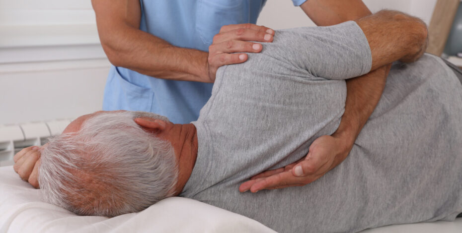 Elderly man receiving a back adjustment